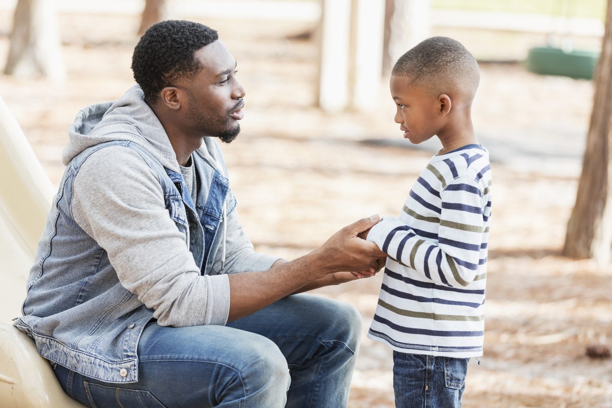 Parent disciplining child at the park after online parenting class that taught him punishment and learning are different approaches.