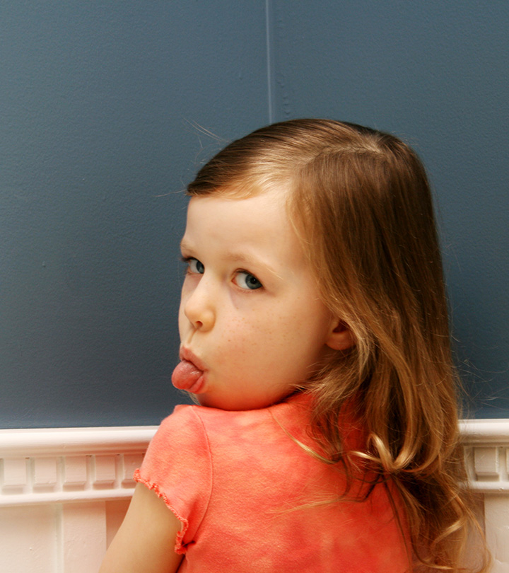 Child facing wall and turning backwards with tongue out to show disrespect.