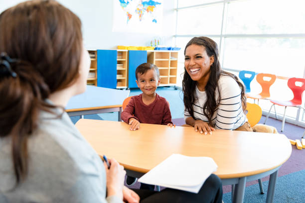 Parent in school with child and teacher smiling. Parent took an online parenting class and the family is happier now.
