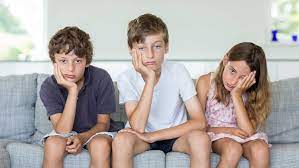 Children sitting on couch feeling bored.