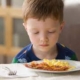Boy staring at food as a picky eater in Ann Arbor, Michigan.