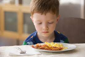 Boy staring at food as a picky eater in Ann Arbor, Michigan.